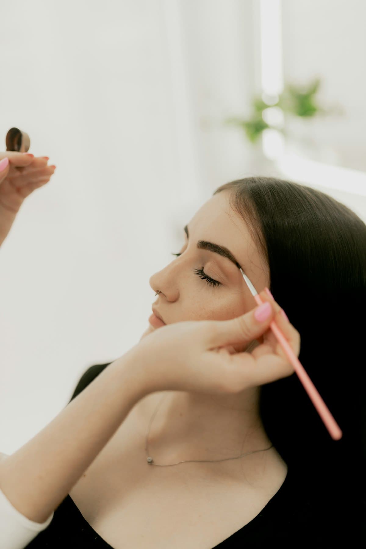 Beautician brushing brows into shape during a lamination service